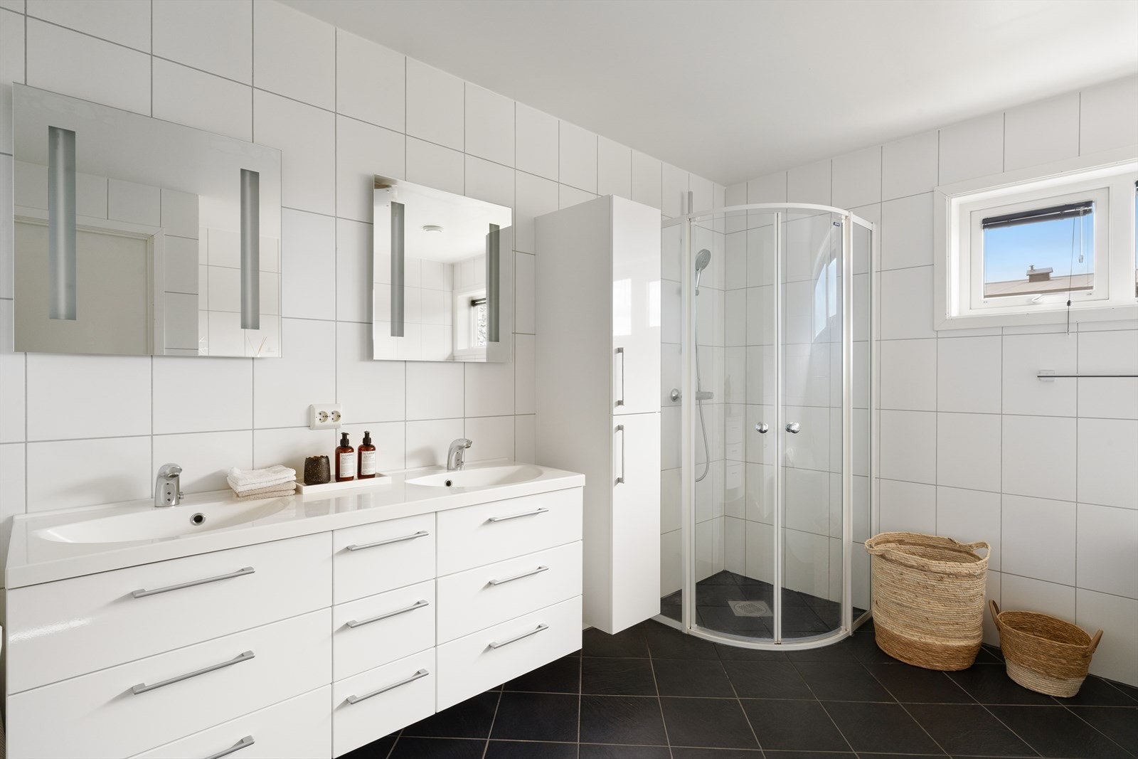 Pent bad som fremstår tidløst, og er innredet med vegghengt wc, dobbel vask i seksjon, hjørnebadekar og dusjhjørne. Det er varmekabler i gulv på badet. Galleribilde