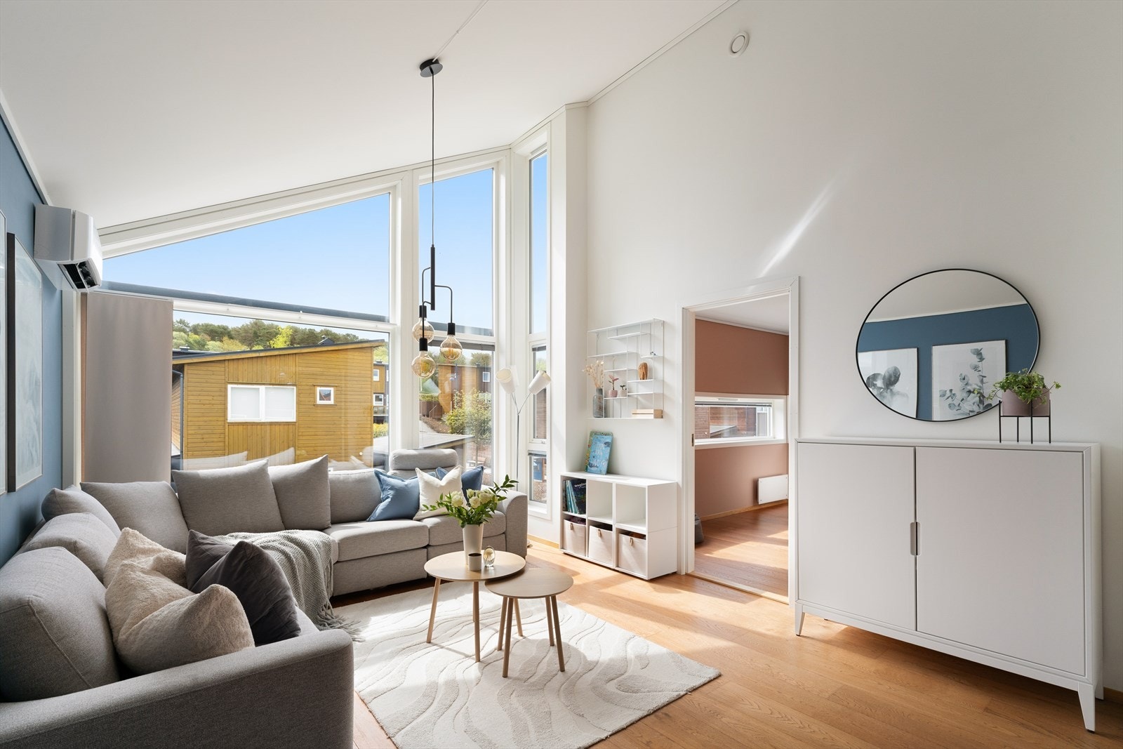 Deler av stuen har vindusflater som strekker seg fra gulv til tak. Den ekstra takhøyden sammen med de store vindusflatene slipper inn rikelig med naturlig dagslys og skaper en god atmosfære i rommet. Galleribilde