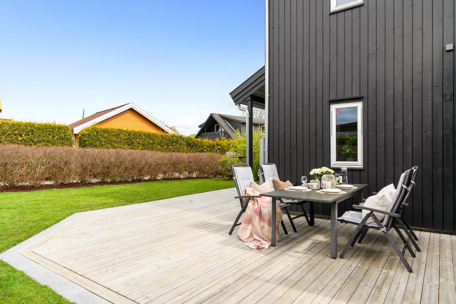 Stor og innbydende terrasseplatting på baksiden av boligen med god plass til utemøbler, grill og sosiale sammenkomster. Galleribilde