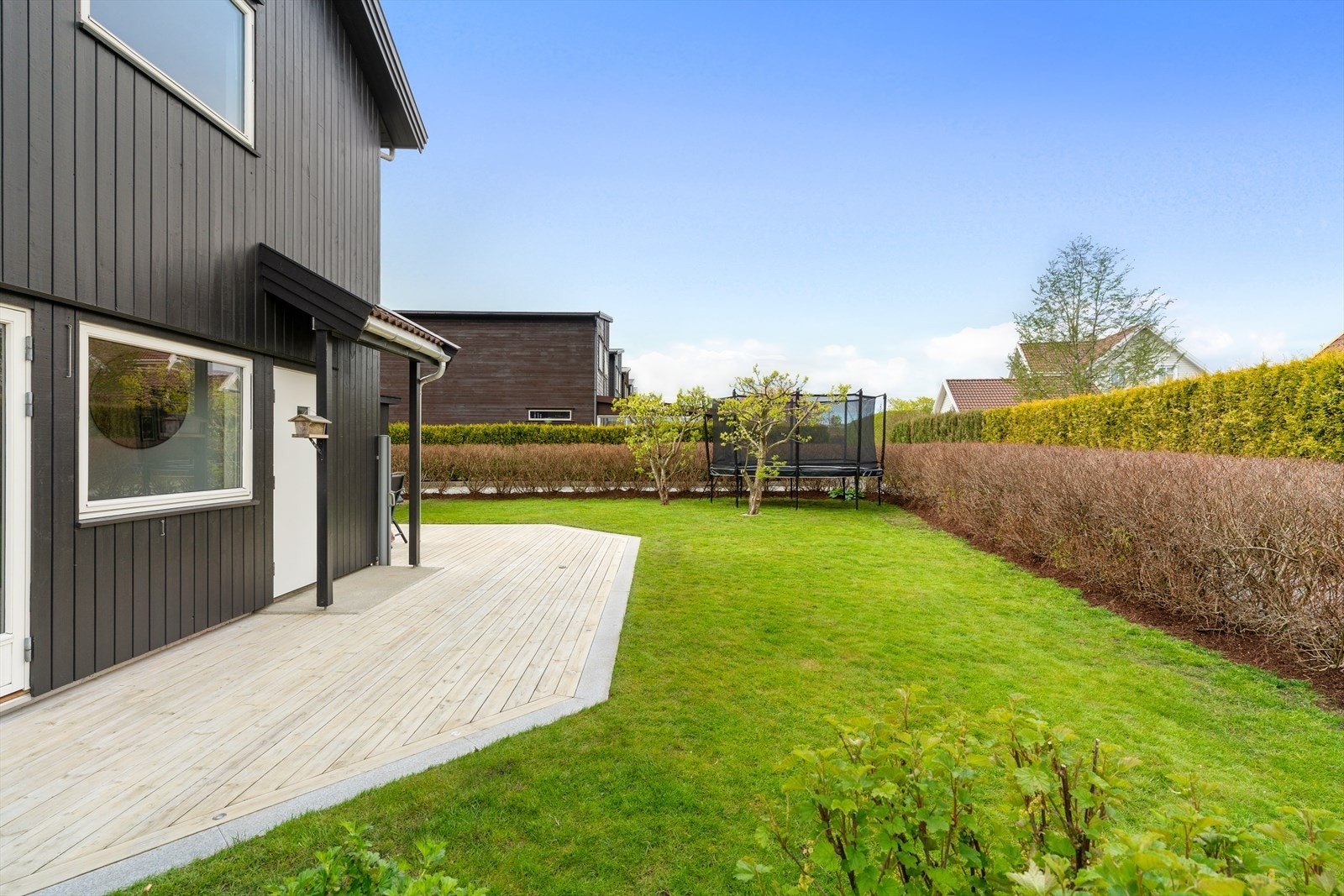 Uteområdet er flott opparbeidet med terasseplatting, gressplen og beplantning med trær og bukser. Galleribilde