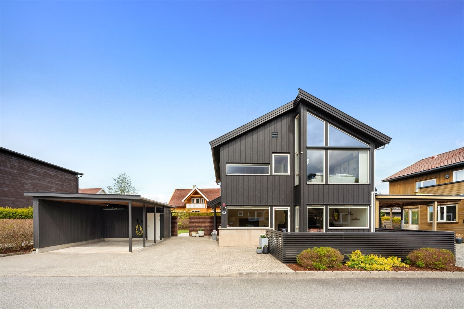 Parkering i carport med elbillader og ellers god plass til flere biler i eget gårdsrom. Galleribilde