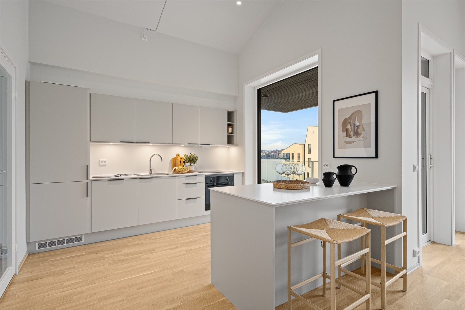 Kjøkkenet er i moderne og fint design med fronter i beige og hvit benkeplate. Kjøkkeninnredning er fra Sigdal. Galleribilde