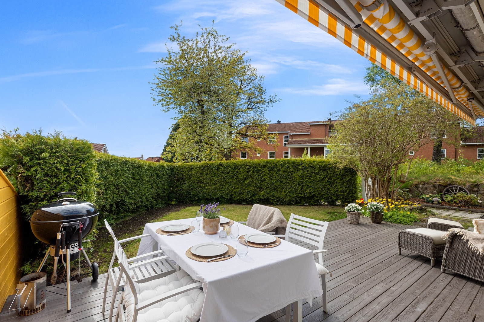 Hagen er skjermet og pent opparbeidet, med terrasseområde og blomsterbed Galleribilde