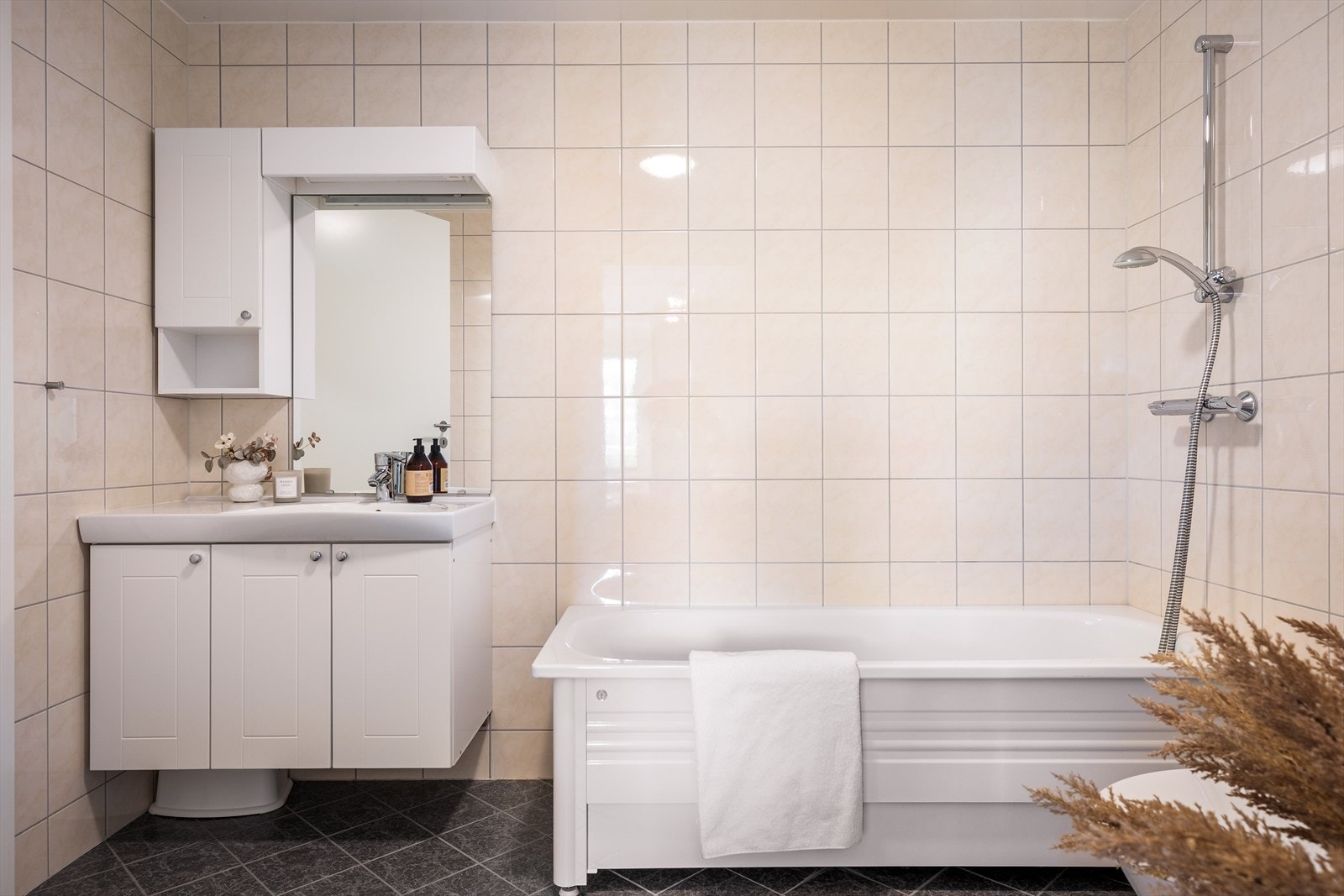 Badet har varmekabler i gulvet, toalett og servant med skapinnredning. Galleribilde