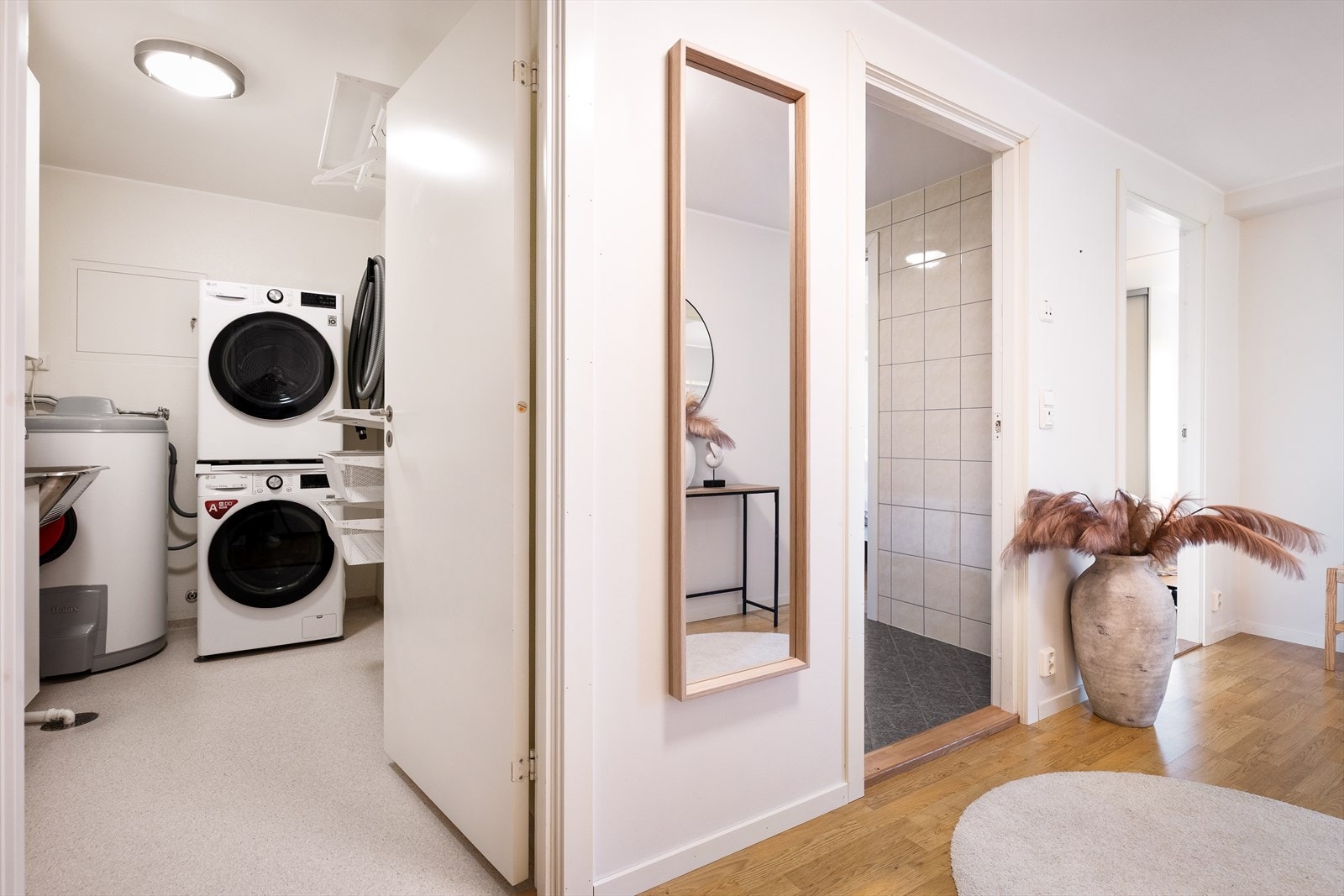 Separat vaskerom med gulvbelegg og opplegg for vaskemaskin. Dette ligger til venstre med en gang man kommer inn i boligen. Galleribilde