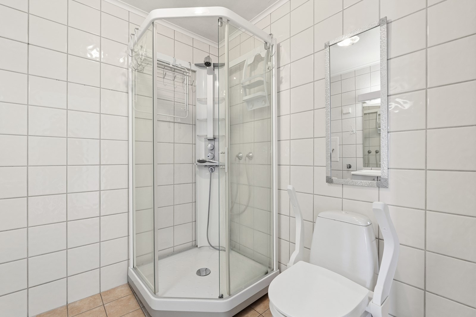 På badet er det dusjkabinett, toalett og baderomsinnredning Galleribilde