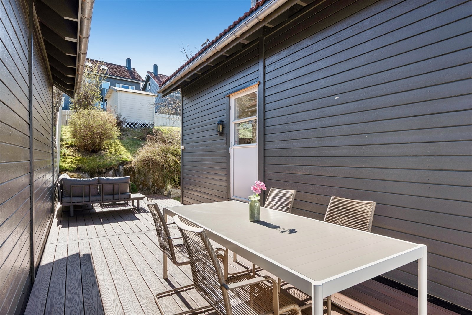 Uteplassen strekker seg langs boligen, og terrassebordene ble skiftet i 2020. Galleribilde