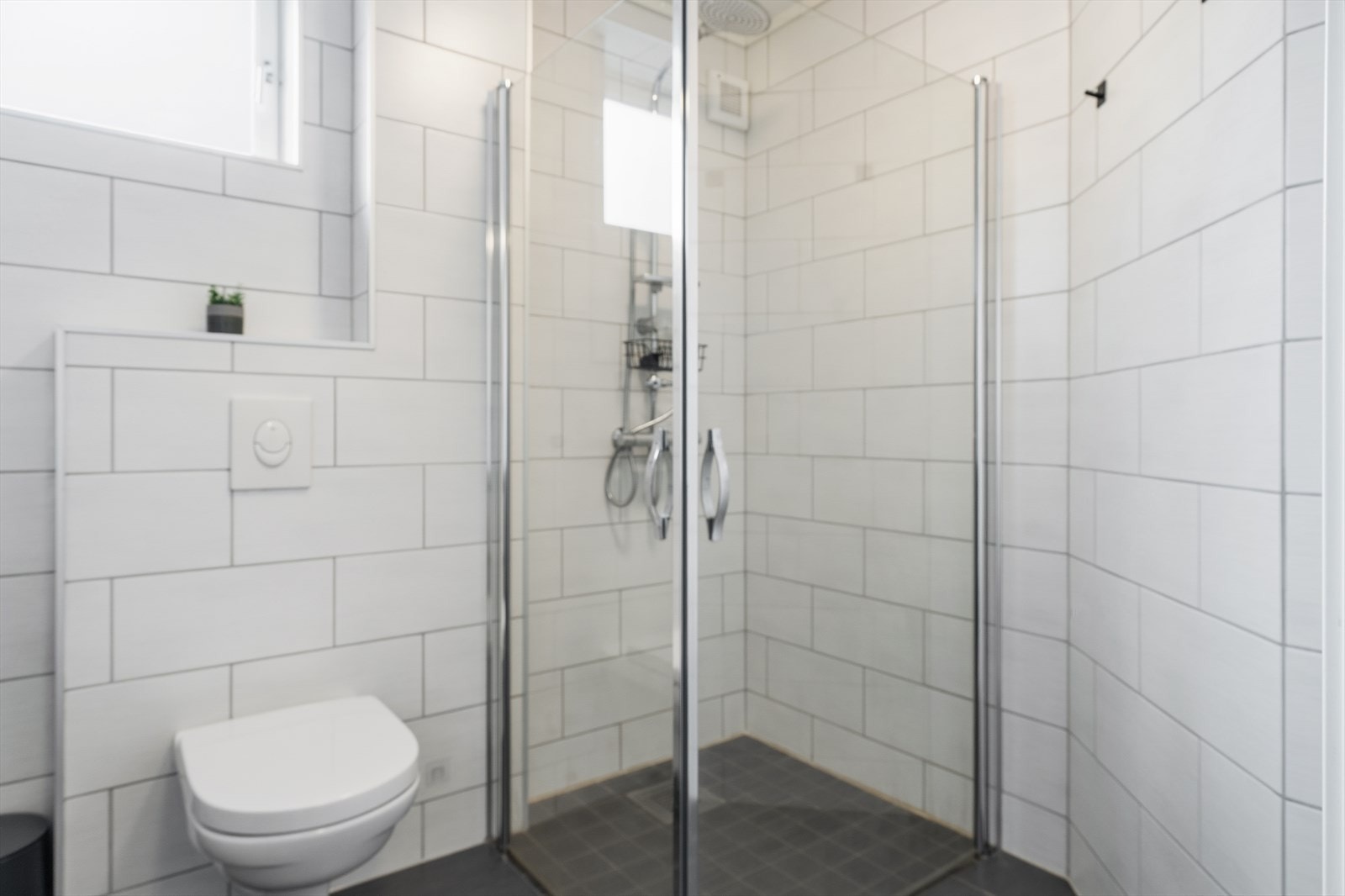 Dusjhjørne med innfellbare glassdører og en sensorstyrt vifte for effektiv ventilasjon. Galleribilde