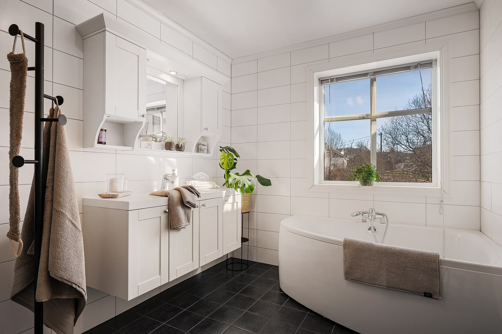 Delikat baderom med flislagte vegger og gulv, samt varme i gulv. Badet er utstyrt med innredning med nedfelt servant, veggmontert toalett, badekar og dusjløsning med glassvegger. Galleribilde