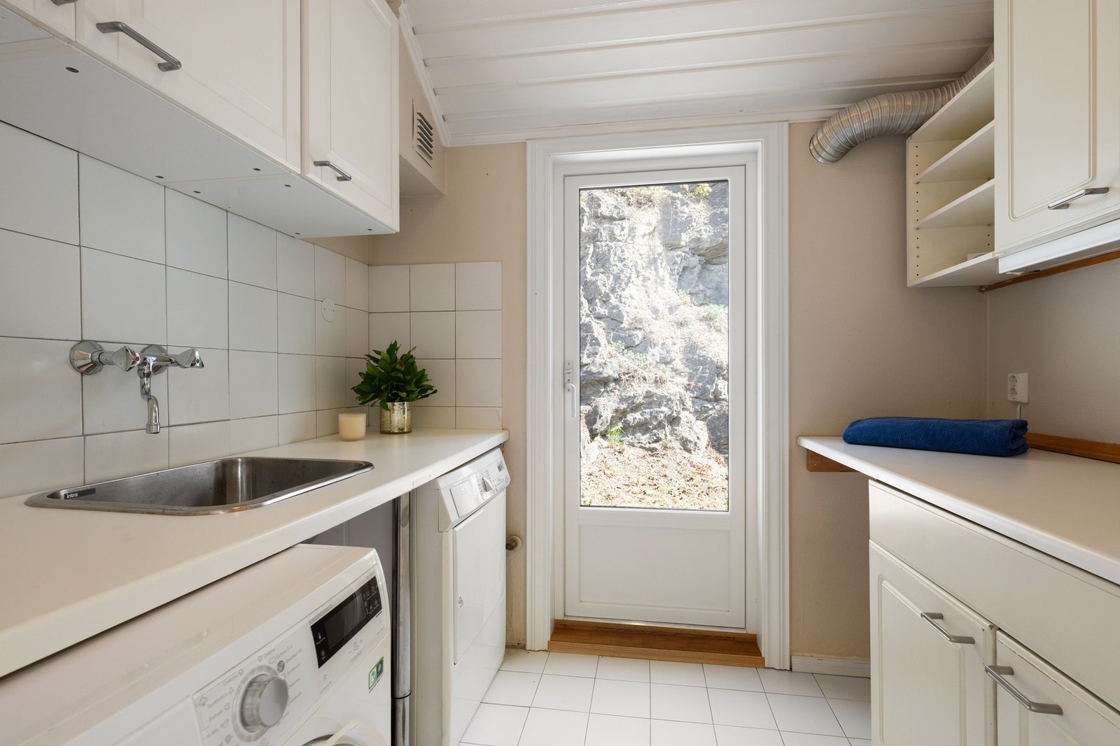 Vaskerommet er i følge eier fra ca 1987. Baderomsinnredning bestående av benkeskap med profilerte fronter. Veggskap med speilfronter over servant. med profilerte fronter. Laminat benkeplate. Skyllekum i rustfritt stål, og opplegg for vaskemaskin. Galleribilde