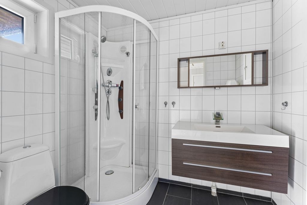 Bad med fliser på gulv og baderomspanel på vegger Galleribilde
