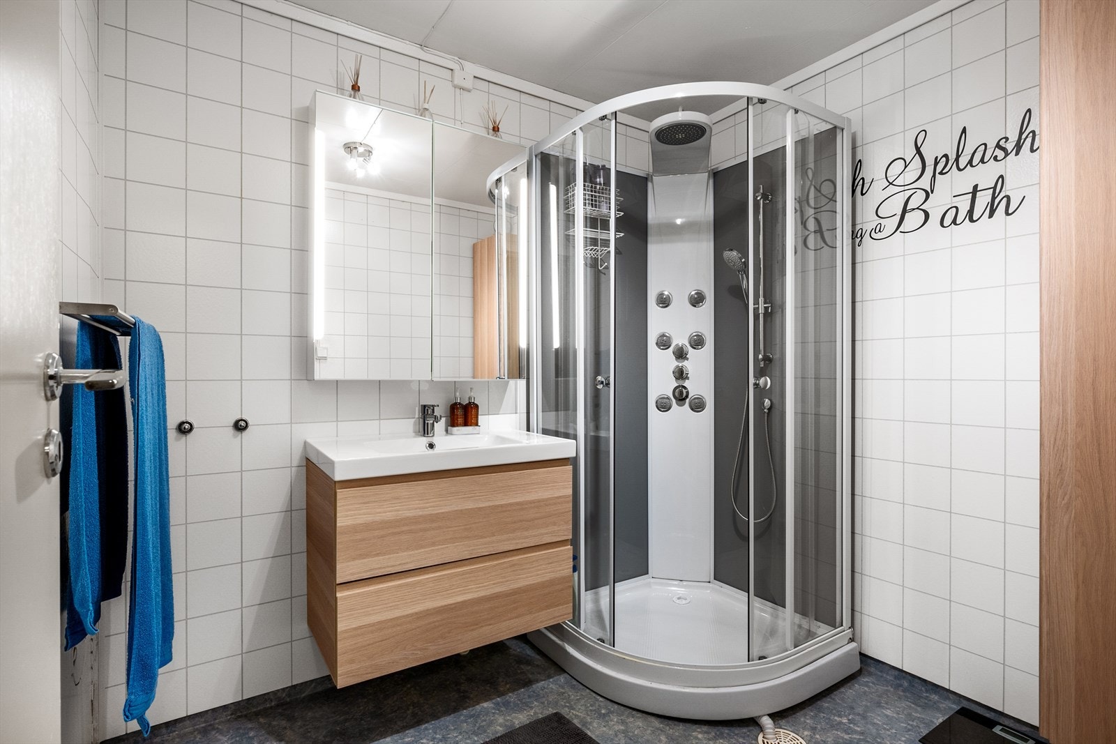 Badet har lyse baderomsplater, gulvet har belegg. Galleribilde
