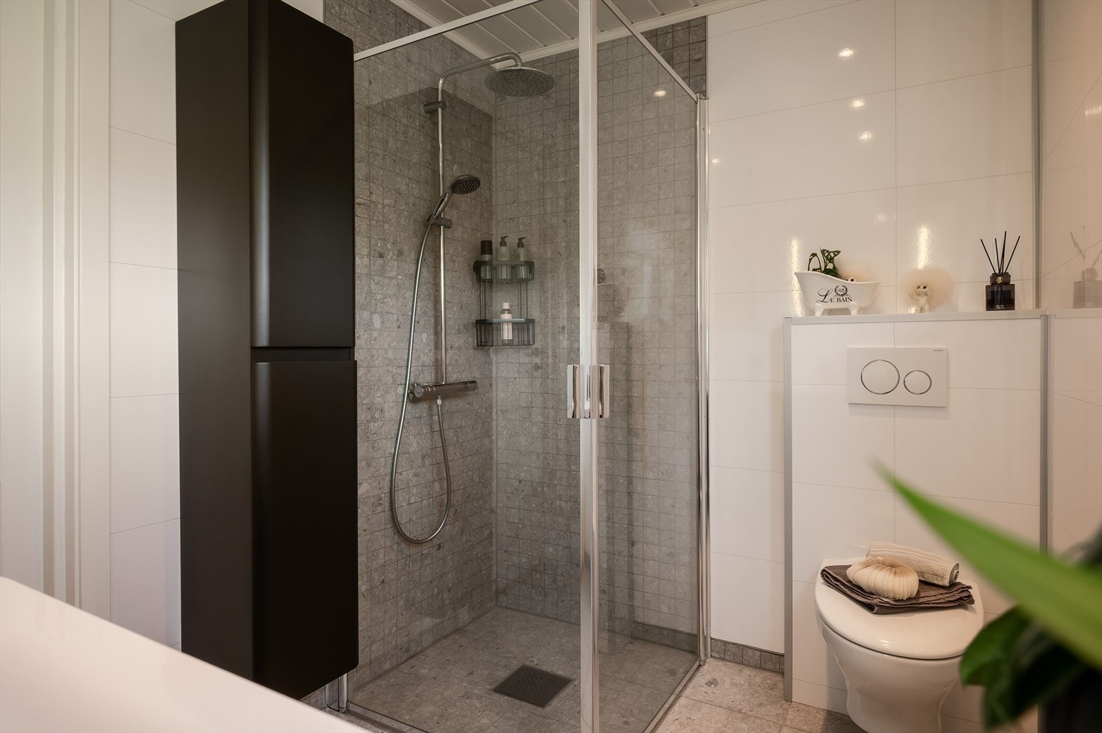 Badet har hjørnedusj, vegg hengt toalett og servant. Galleribilde