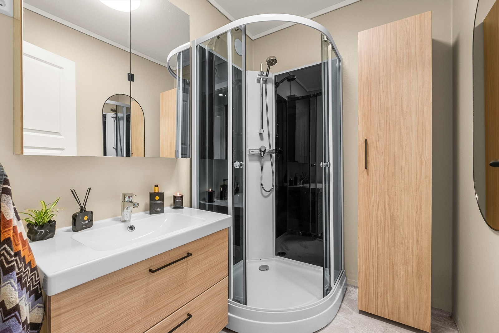 Badet måler 3 kvm og er innredet med servantskap med overskap og sideskap samt dusjkabinett. Galleribilde