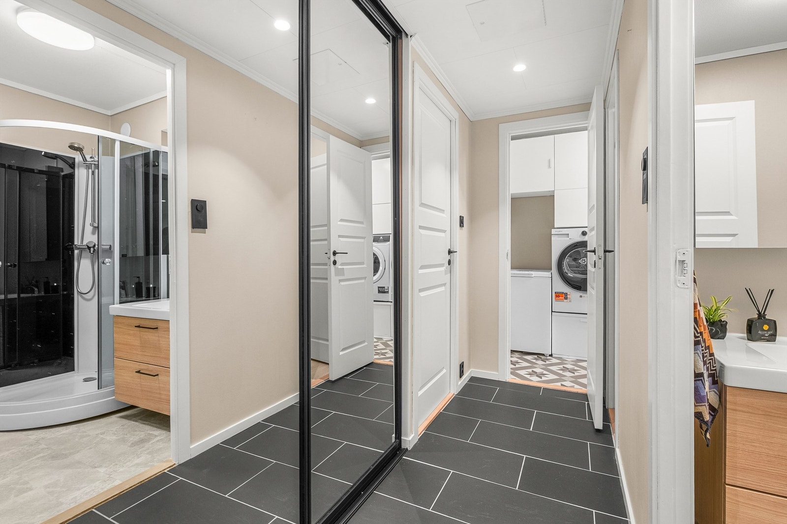 Romslig entré med praktisk plassbygd skyvedørsgarderobe. Galleribilde