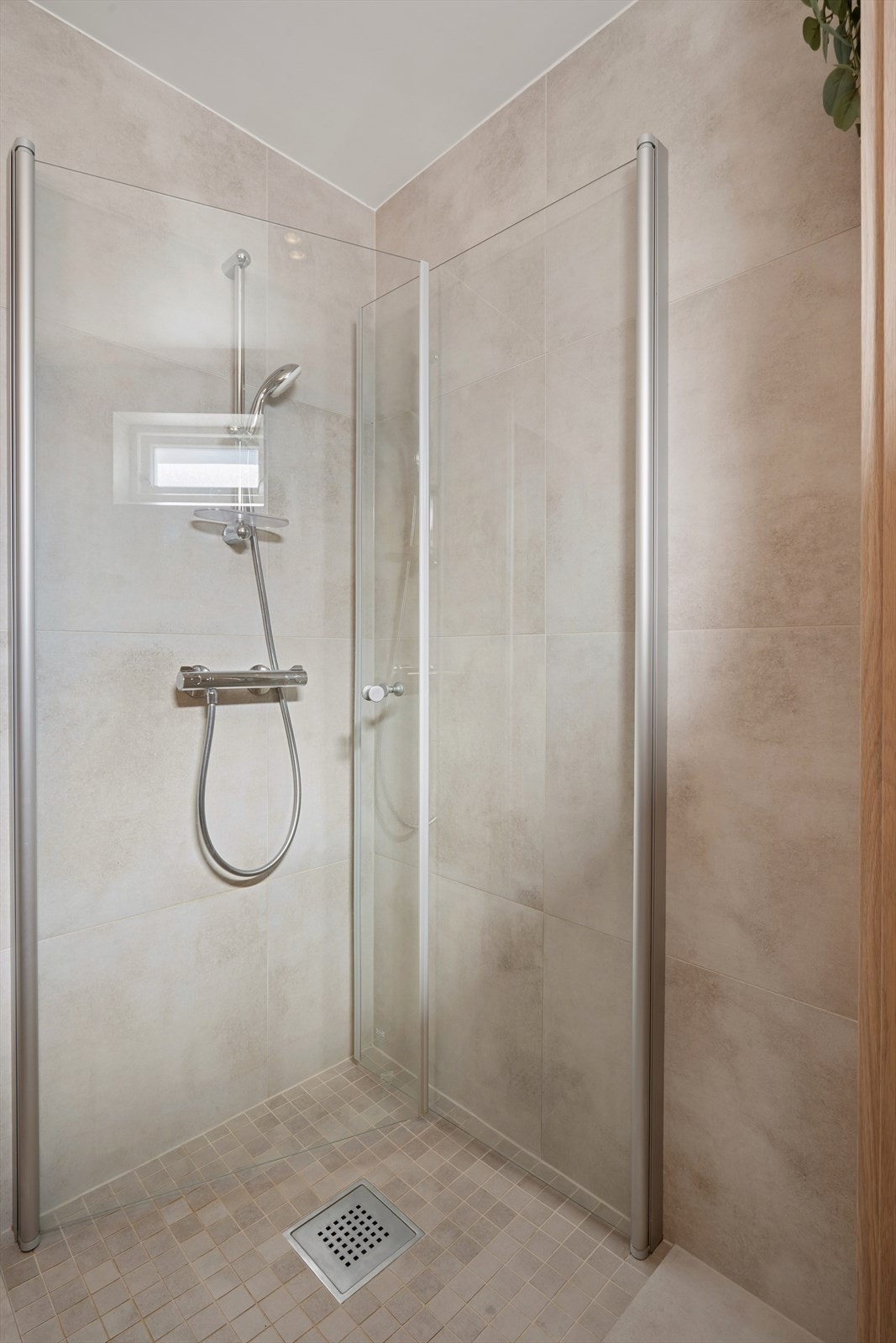 Badet er utstyrt med dobbel servant, dusjhjørne og oppbevaringsmøbler. Galleribilde