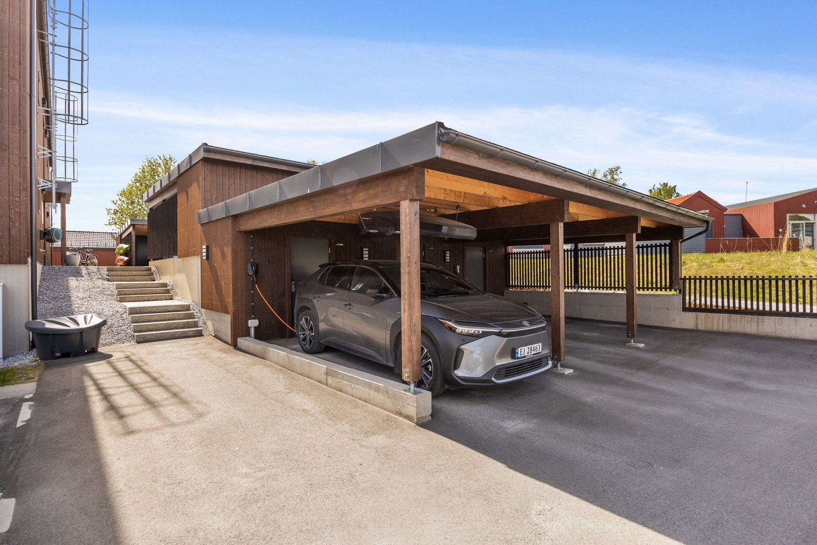 Parkering i carport. Det er montert elbillader. Galleribilde