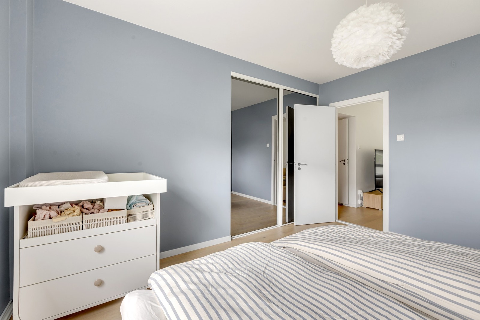 Videre tilbyr rommet rikelig med oppbevaringsplass i plassbygget garderobe med både skuffer og skap, samt skyvedørsgarderobe. Galleribilde