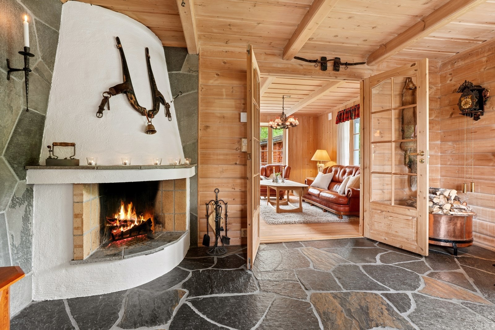 Peisestuen har en stemningsfull, åpen peis og skifer på gulvet. Dobbeldører åpner inn mot hovedstuen. Galleribilde