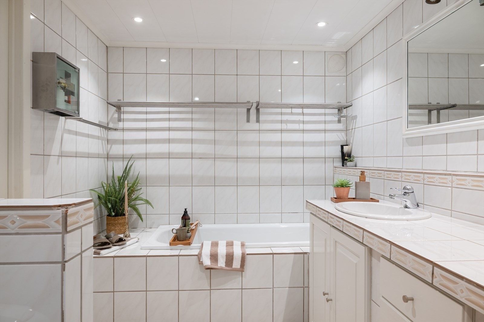 Badet er romslig og er ellers utstyrt med toalett, dusjnisje, badekar og baderomsinnredning med servant. Rommet har naturlig ventilering via ventil i tak og mangler tilluftsventilering (se punkt "ferdigattest"). Galleribilde