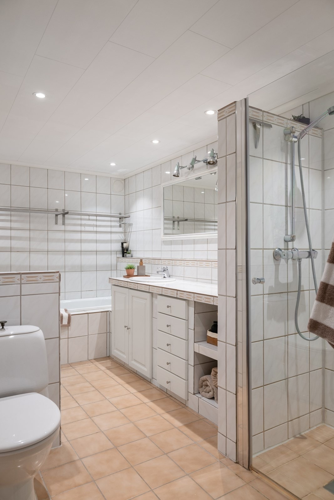 Badet er av eldre dato og er innredet med lyse fliser på gulv og vegger. I gulvet har man også varmekabler for ekstra komfort (se punkt "ferdigattest"). Galleribilde