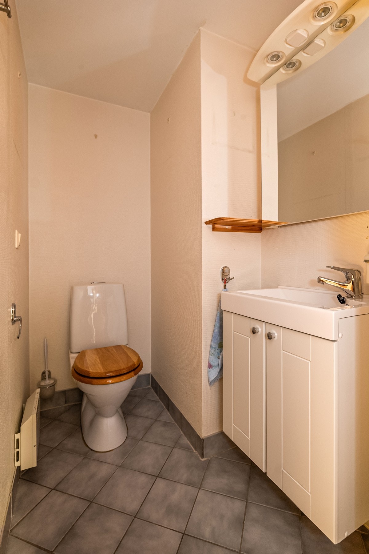 Toalettrommet er utstyrt med servant og WC. Det er fliser på gulv, malt vegg og himling og oppvarming med panelovn. Galleribilde