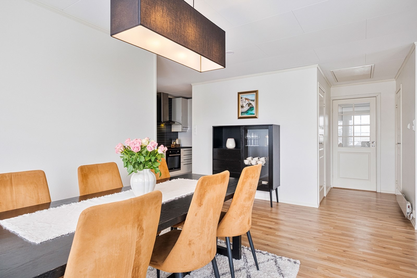 Spiseområdet er godt belyst av en hengende lampe som gir et behagelig miljø. Galleribilde
