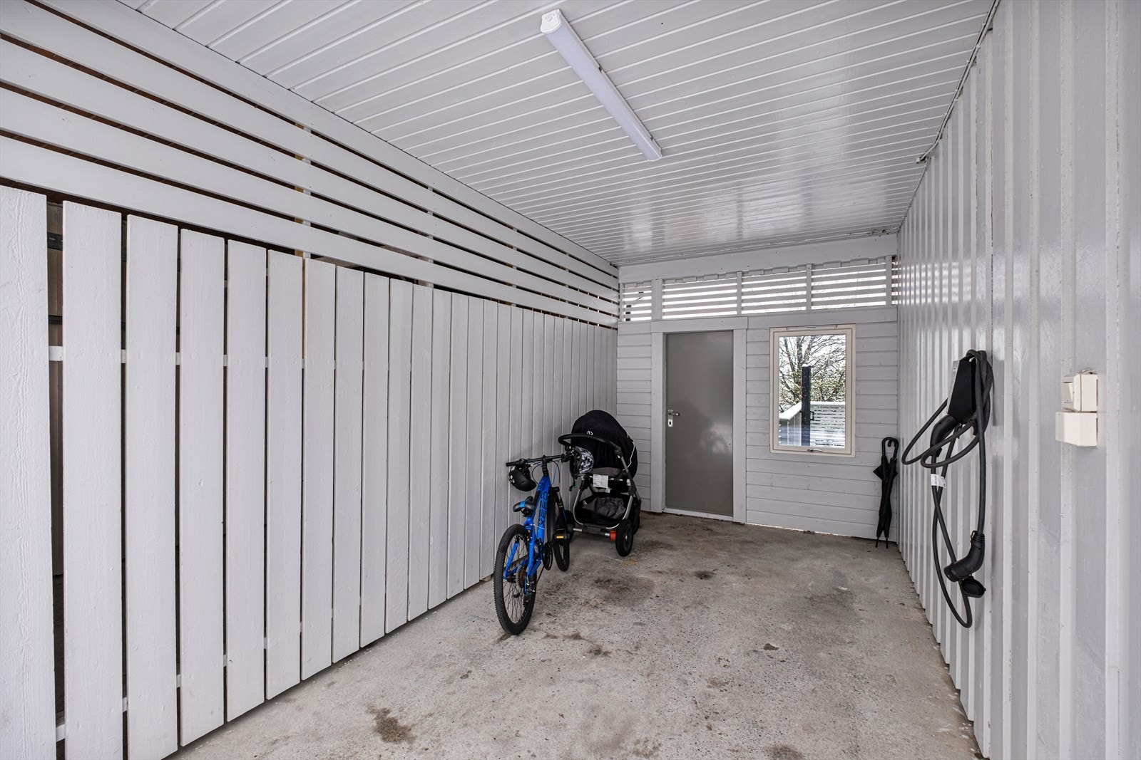 Boligen har parkering i carport med elbil-lader. Galleribilde