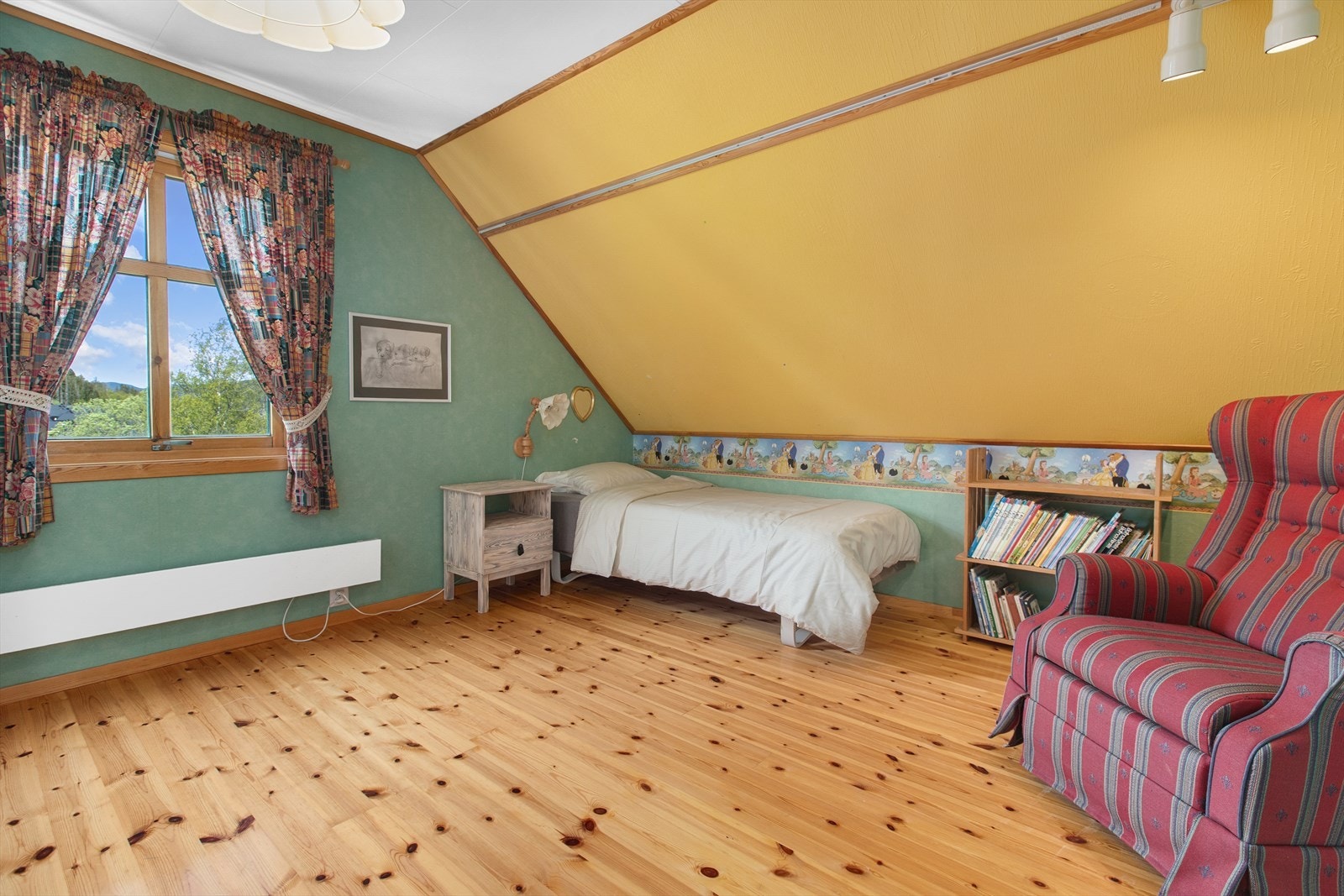 Romslig soverom med sjarmerende skråtak og plass til både seng og sittegruppe. Galleribilde