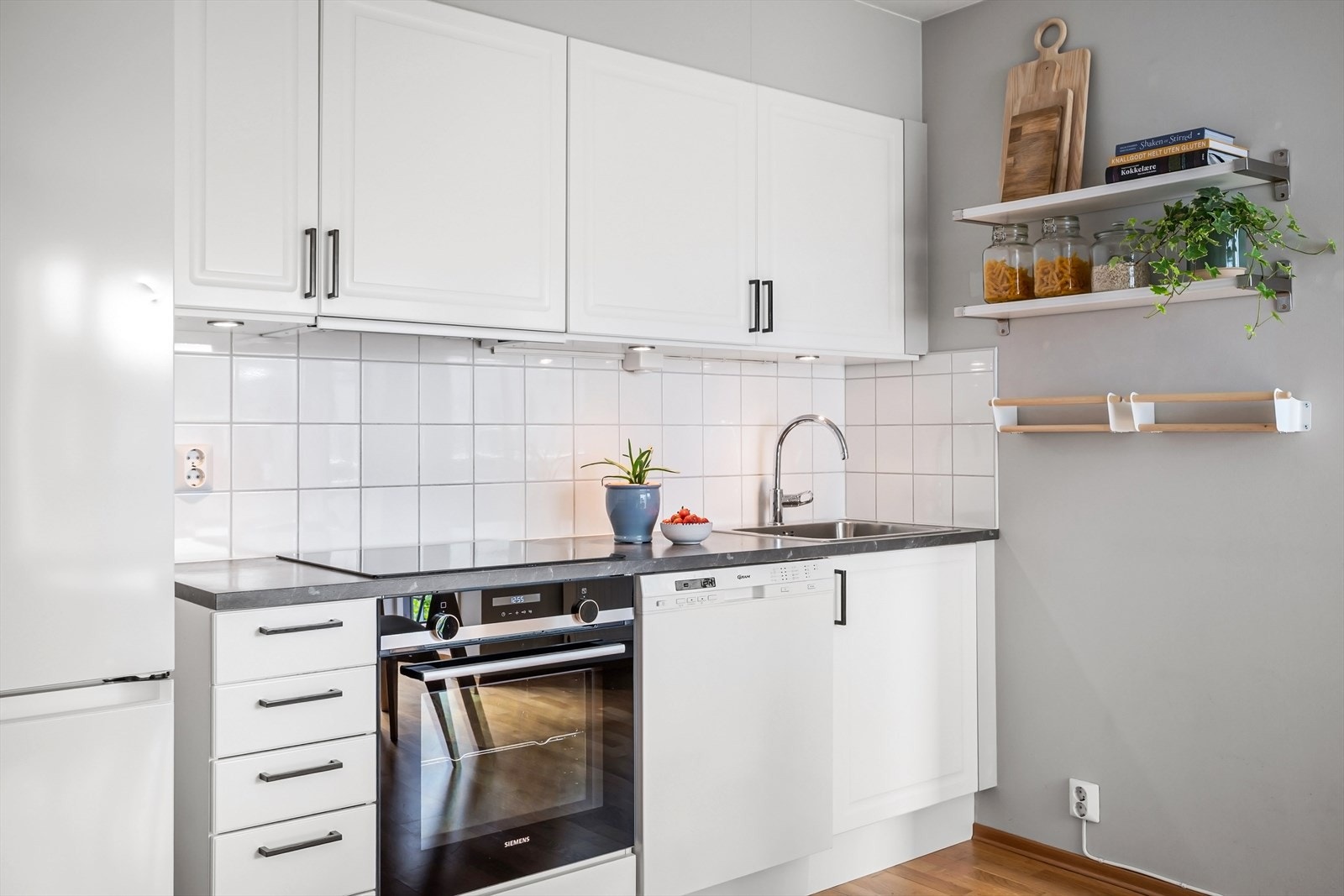 Kjøkken har profilerte fronter, fliser på veg og laminat benkeplate. Ventilator og opplegg for oppvaskmaskin. Galleribilde