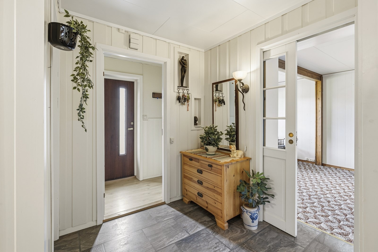 Fra gangen er det enkel adkomst til alle rommene i underetasjen, blant annet til en egen stue i sørenden av boligen. Galleribilde