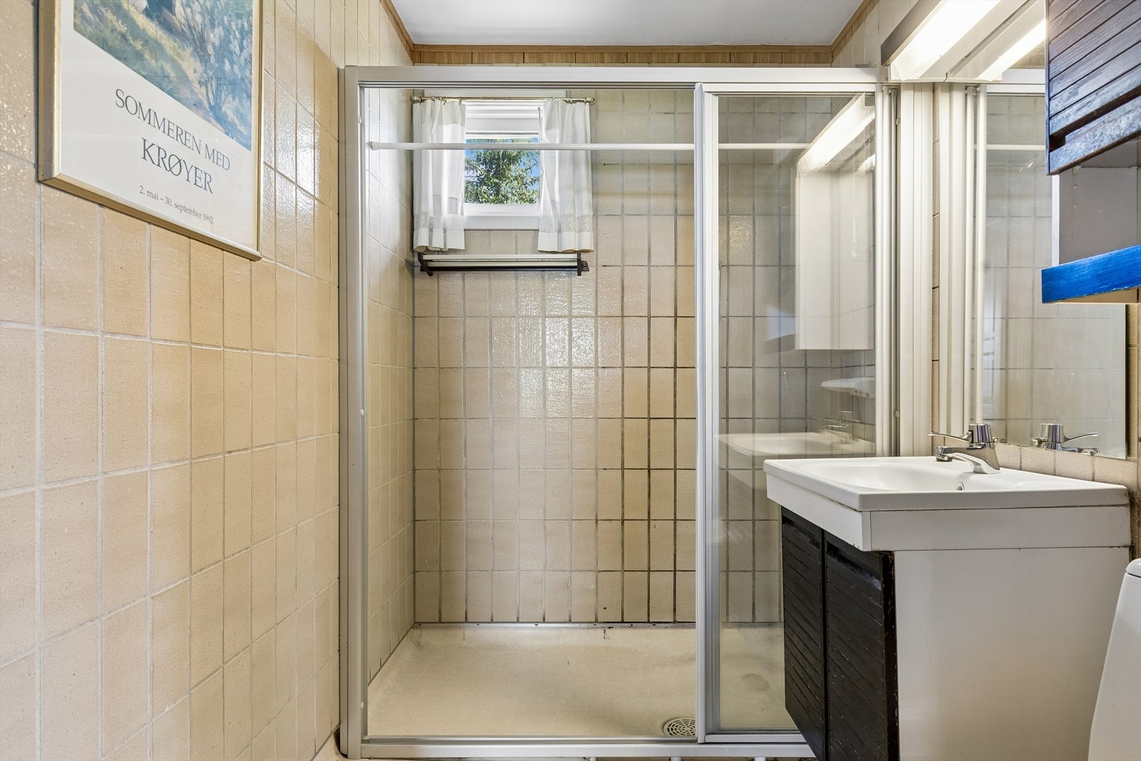 Bad i første etasje med flislagte vegger og nedsenket dusjnisje. Galleribilde