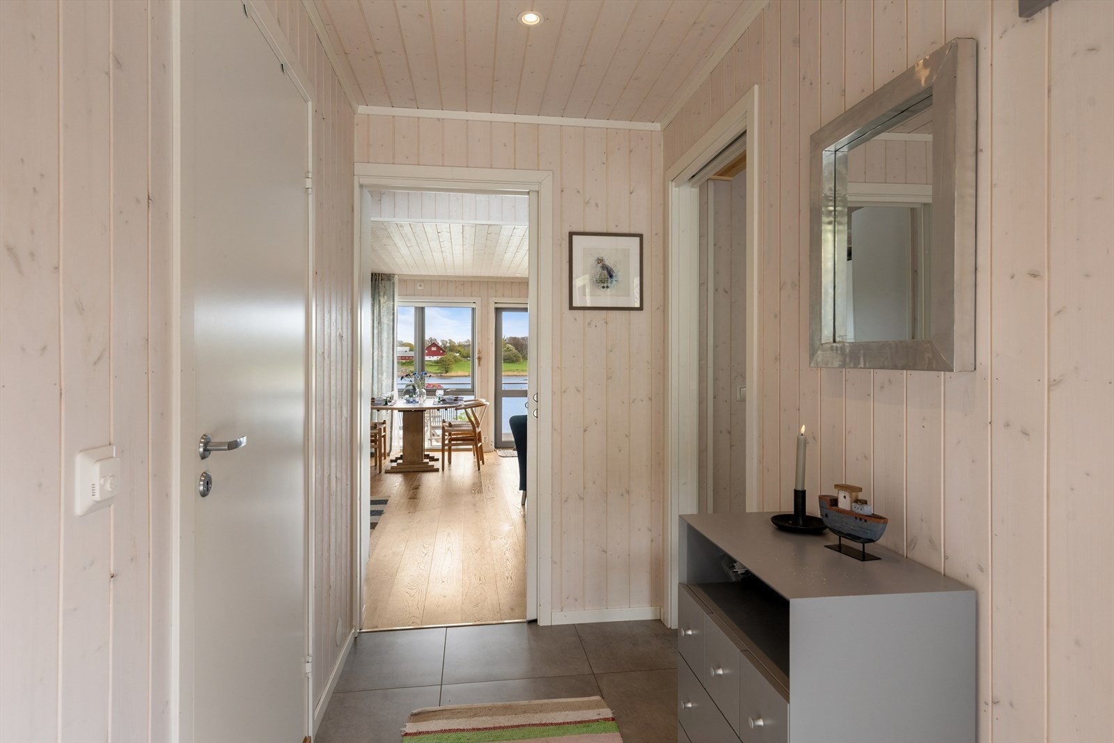 Entréen har flislagt gulv og gir direkte innsyn til stuen og utsikten mot Vikerøysundet. Galleribilde
