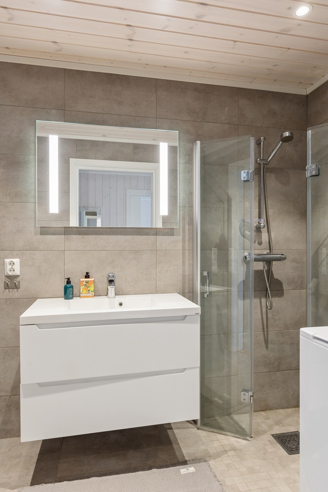 Badet i første etasje har flislagte overflater, varmekabler i gulvet og en nedsenket dusjnisje. Galleribilde