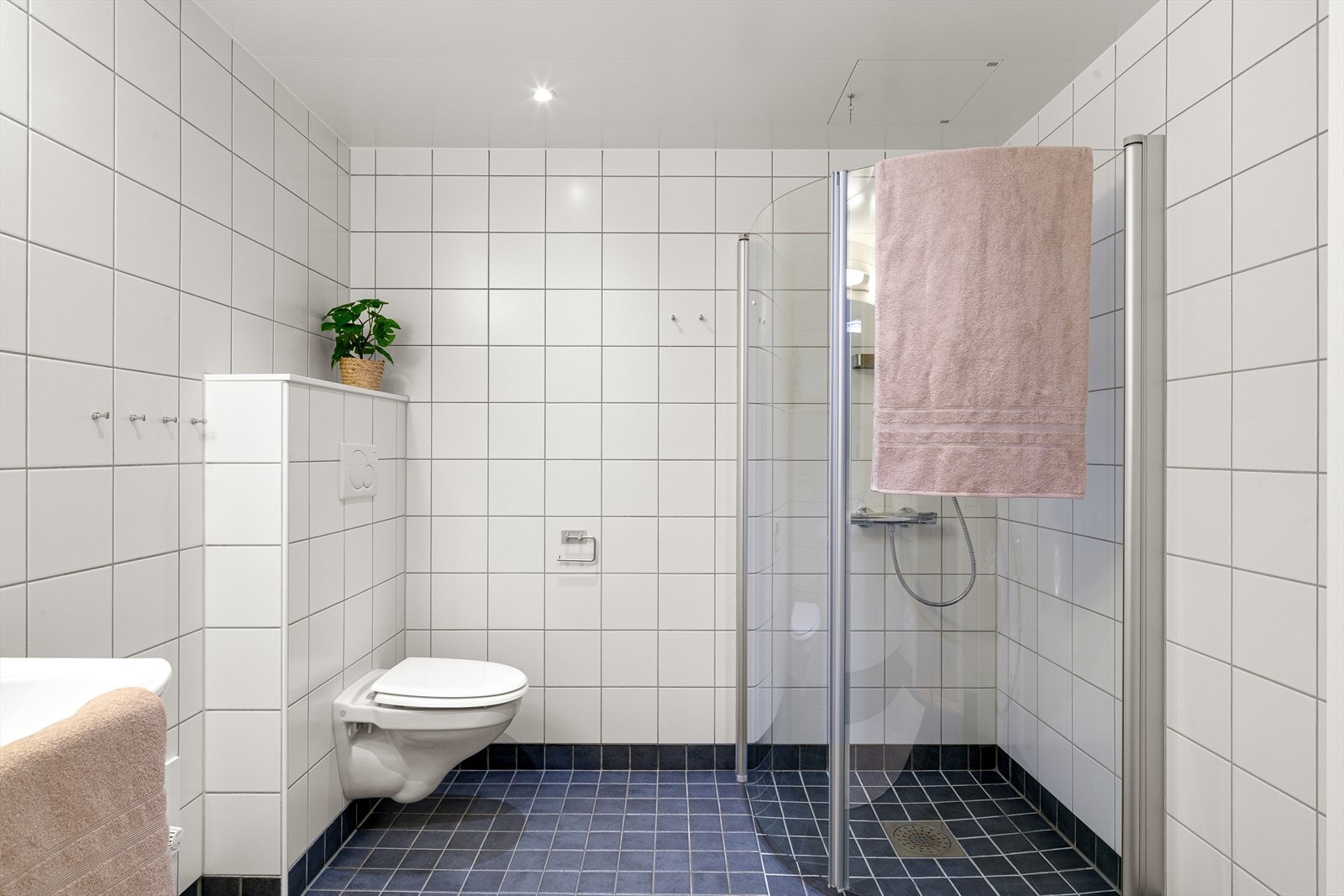Badet fremstår tidløst med fliser på gulv og vegger, downlights i himling og vannbåren gulvvarme. Galleribilde