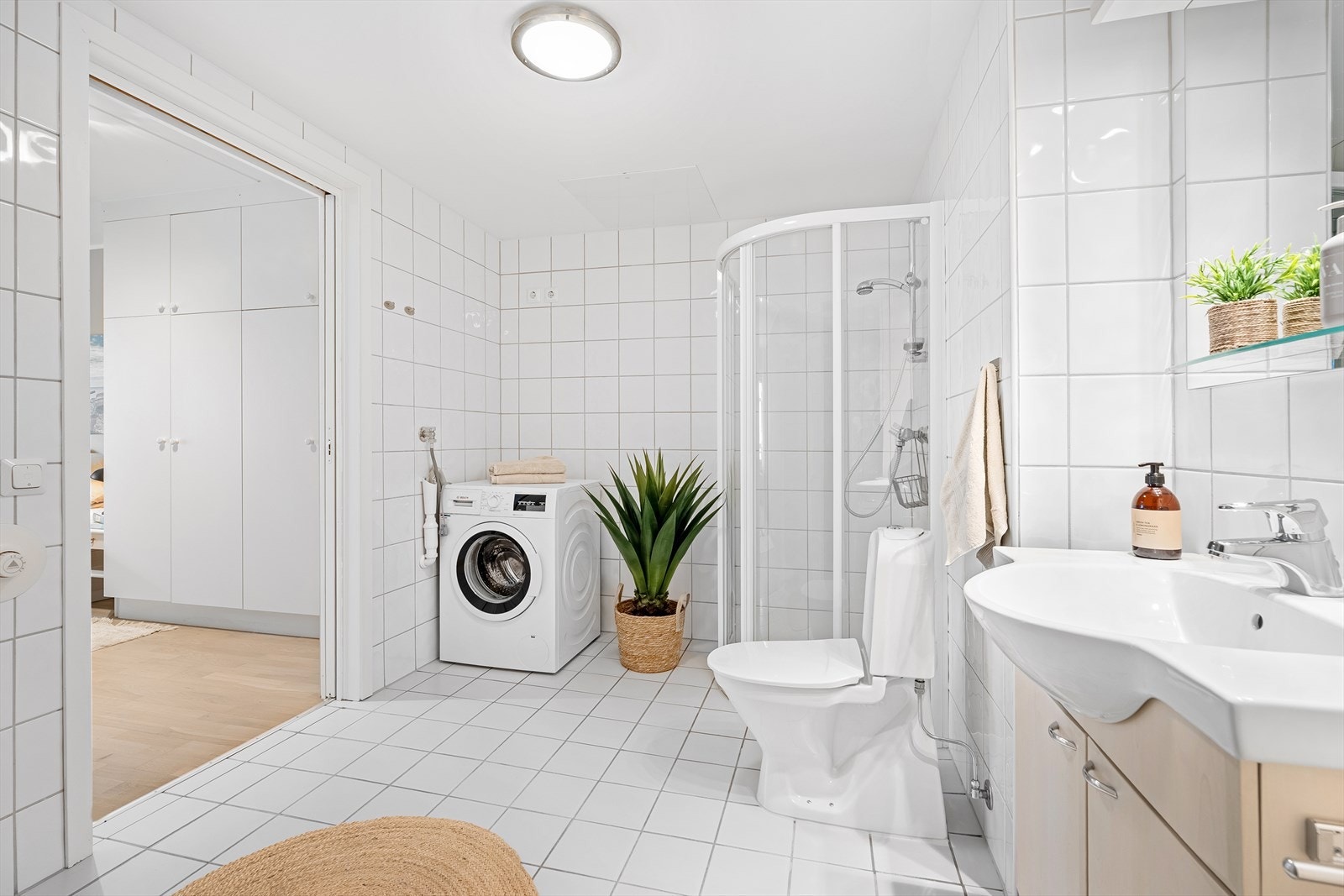 Badet er helfliset med varme i gulvet og inneholder alt du behøver som dusjnisje, baderomsinnredning med speil over, toalett, samt plass og opplegg for vaskemaskin og tørketrommel om ønskelig. Galleribilde