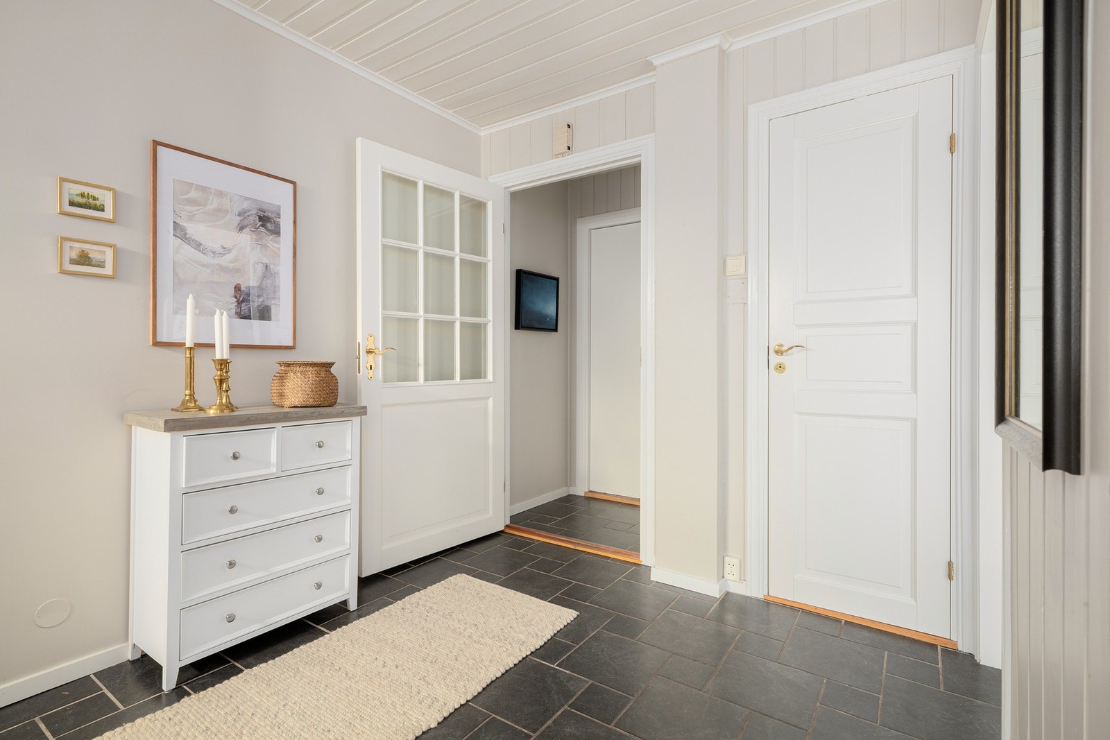 Romslig, flislagt hall med behagelig gulvvarme og toalettrom i praktisk tilknytning. Galleribilde