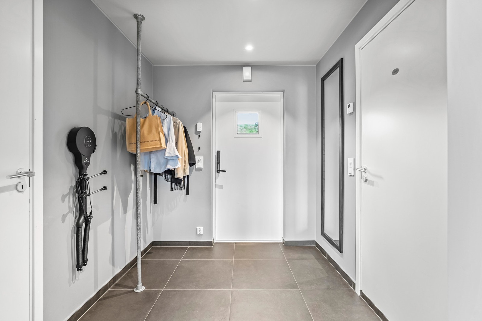 Entreen er pent innredet med mørke gulvfliser, slette, malte veggflater og downlights i himling. Fra entreen er det også direkte adkomst til en innvendig bod, som gir ekstra gode oppbevaringsmuligheter. Galleribilde