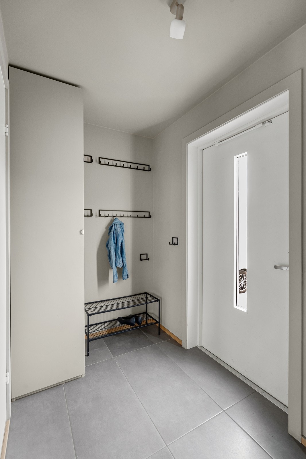 Lys, innbydende entre med oppheng og garderobe til ytterklær. Galleribilde