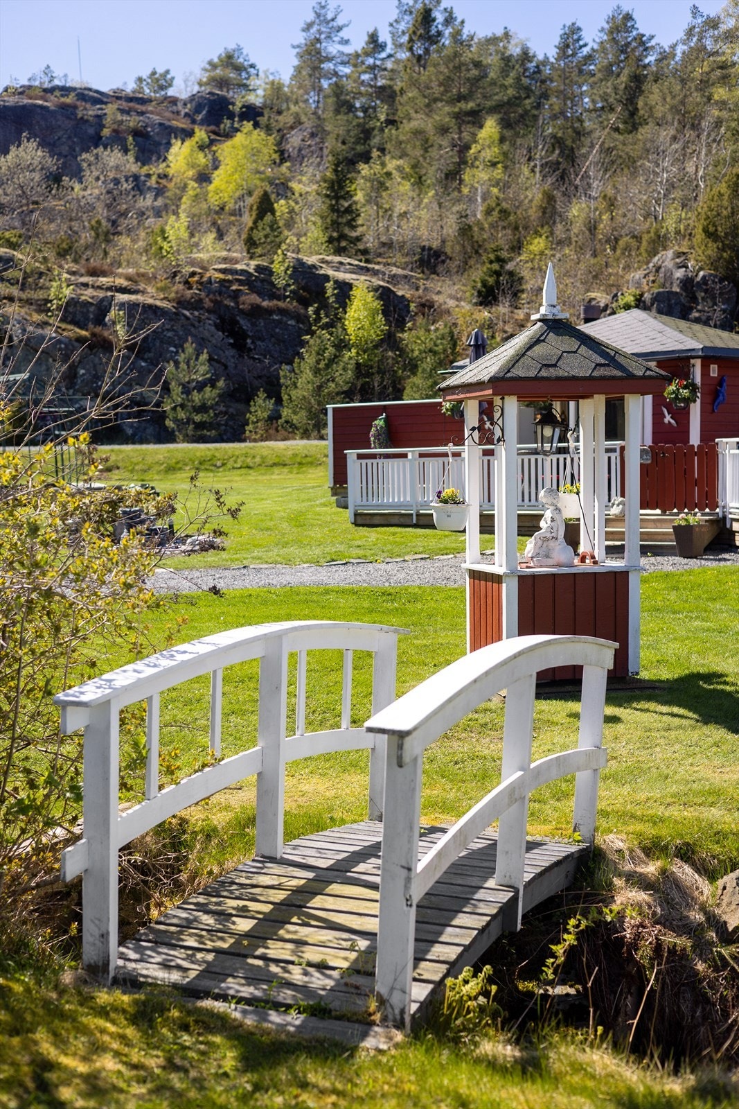 Sjarmerende detaljer i hagen skaper en idyllisk ramme rundt eiendommen. Galleribilde