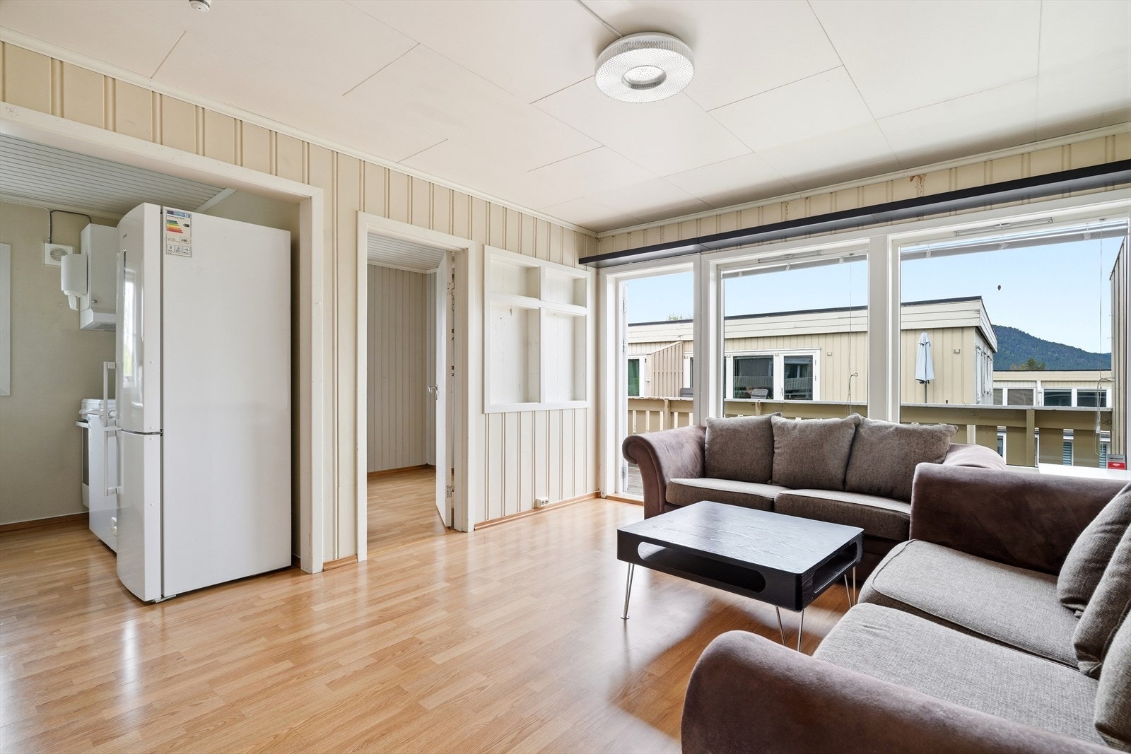 Store vindusflater og terrassedør i tre med isolerglass gir godt med lys og leder ut til balkongen. Galleribilde