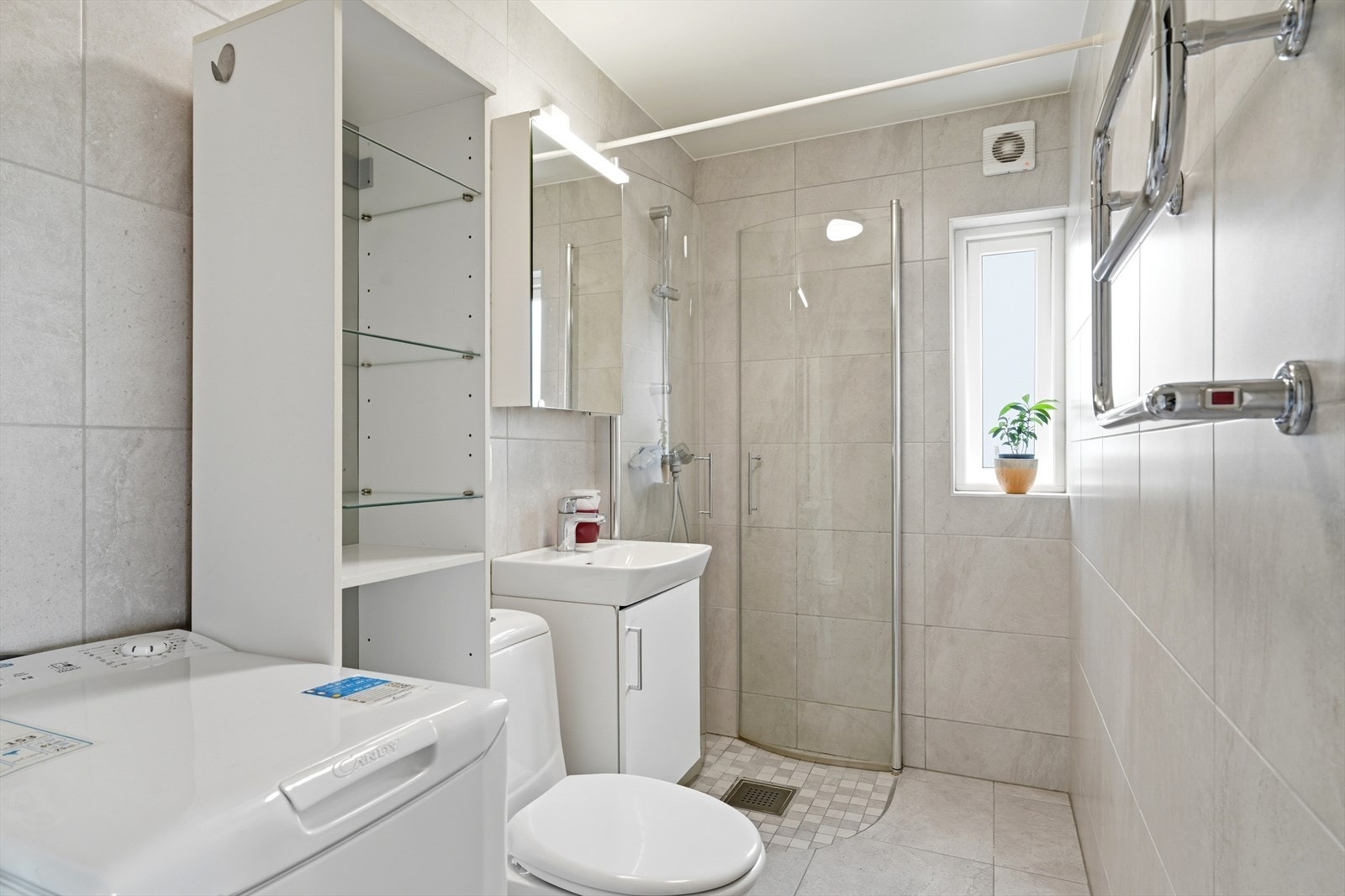 Badet er utstyrt med dusjhjørne, håndkletørker og har opplegg for vaskemaskin. Galleribilde