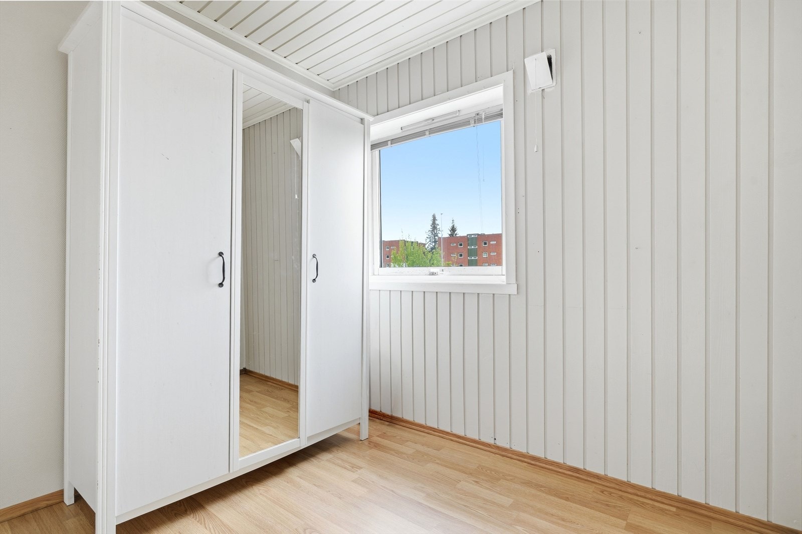 Rommet har panel på veggene og laminatgulv, i tråd med resten av leiligheten. Galleribilde