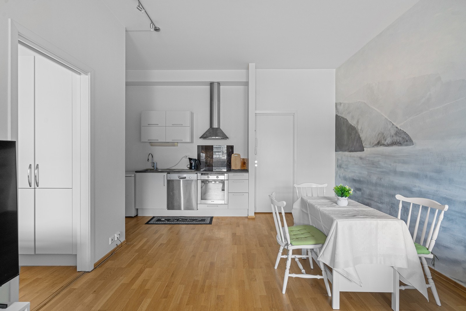 Kompakt kjøkken med laminat benkeplate og integrert koketopp. Galleribilde