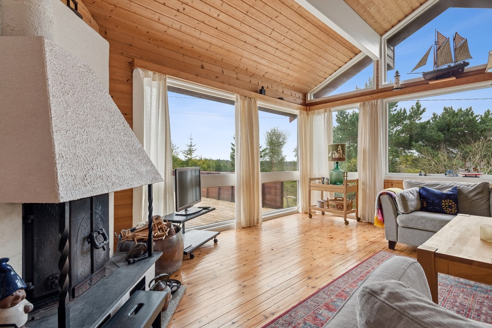 Stue har store vinduer som gir legg og naturlig lysinnslipp. Galleribilde