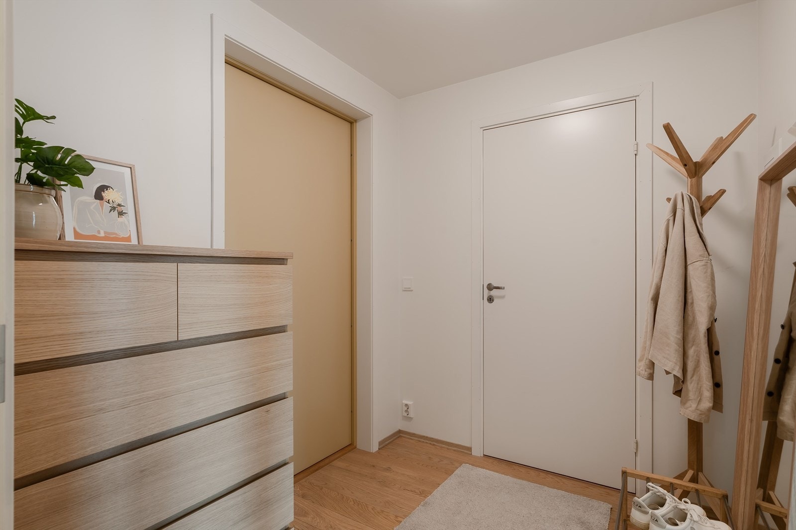 Leiligheten har en praktisk entré på ca. 4 m² som gir et ryddig og funksjonelt førsteinntrykk. Her er det parkett på gulv, lyse vegger og god plass til oppbevaring av sko og yttertøy. Galleribilde