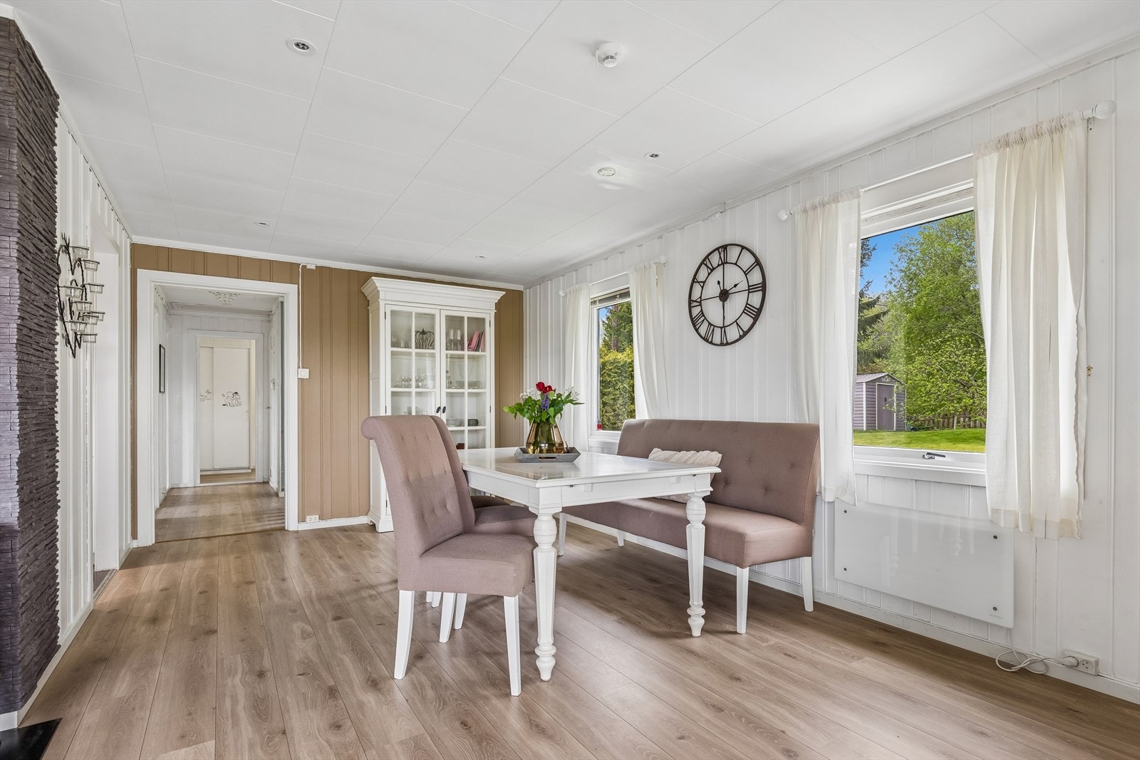 Gjennomgående laminatgulv og panel på veggene skaper en helhetlig stil i oppholdsrommene. Galleribilde
