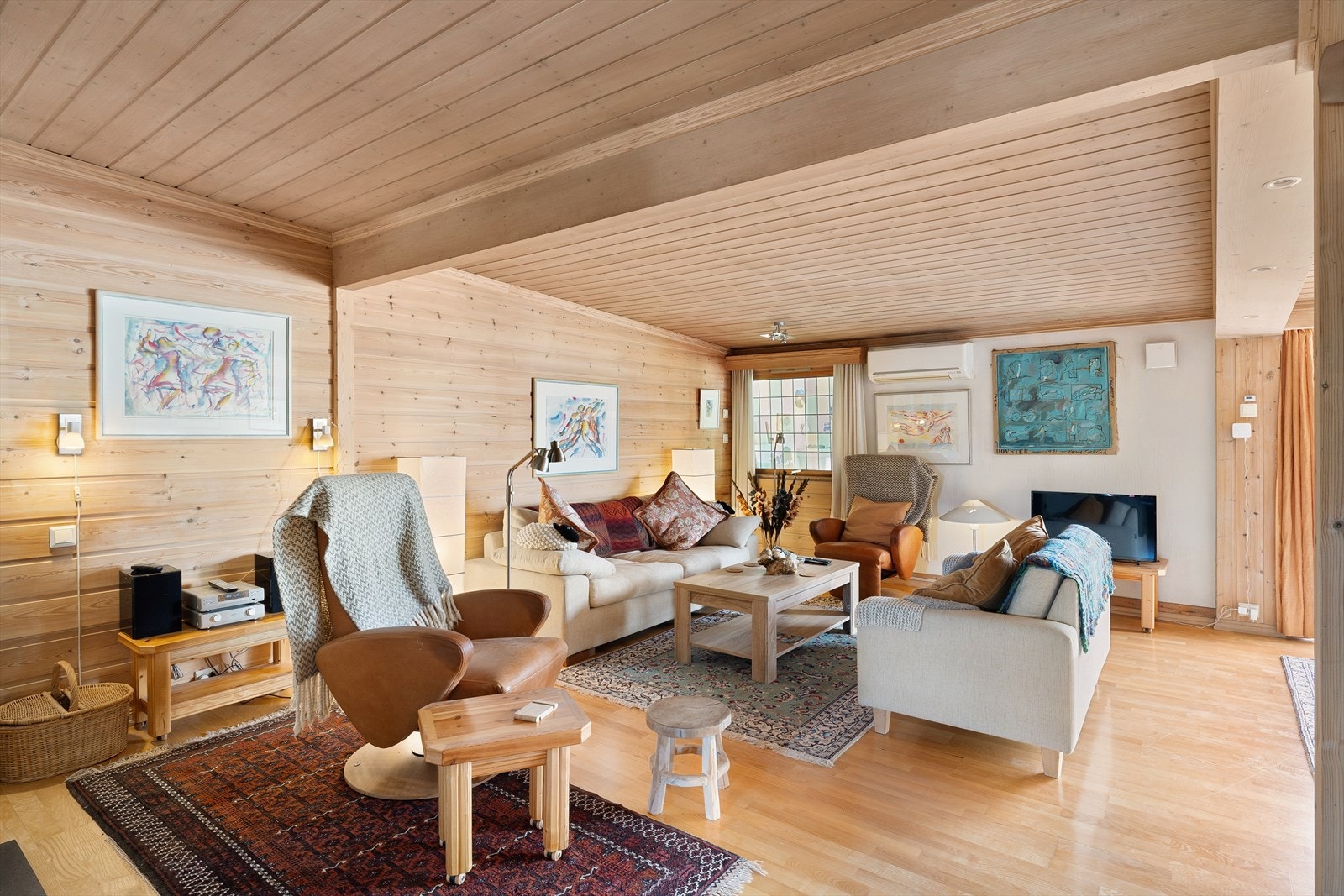 Overflatene har parkett på gulvet og vegger med panel og malt betong. Varmepumpe og peis. Galleribilde