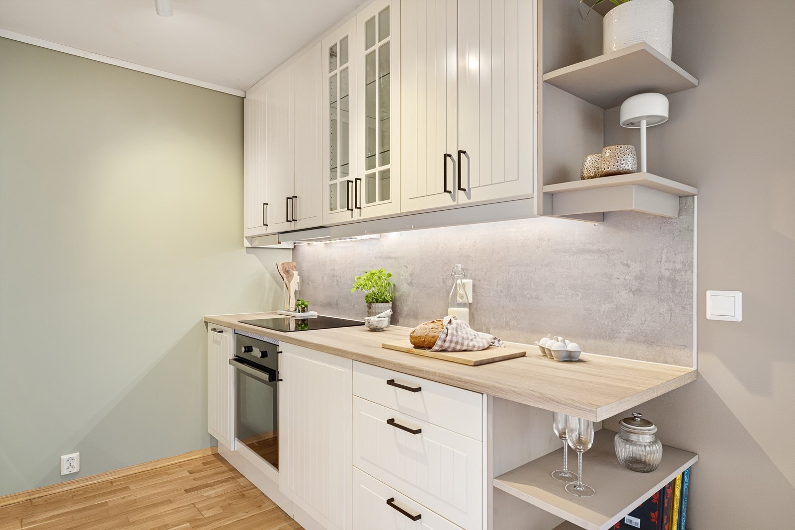 Kjøkkenet har flott innredning med rillede fronter/vitrineskap, benkeplate i laminat og nedfelt vask med ett-greps blandebatteri. Her er kitchenboards over benkeplaten og belysning/stikkontakt under overskap. Galleribilde