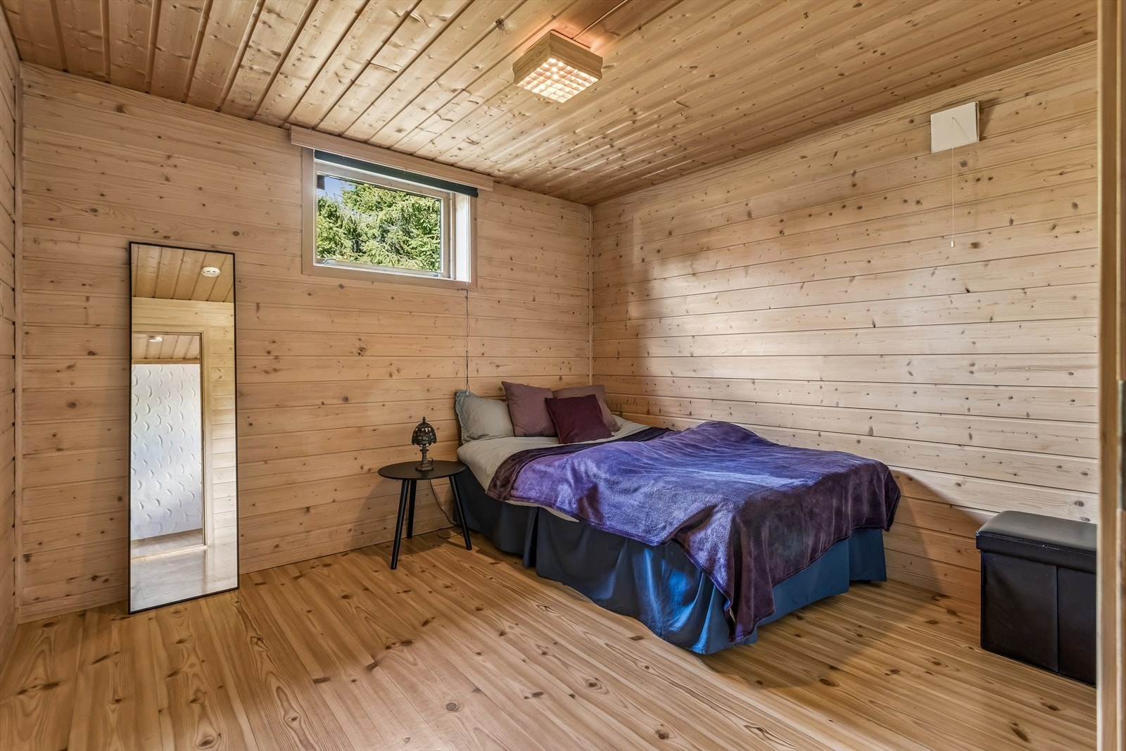 Soverom i kjelleretasjen med panel på vegger og tak. Galleribilde
